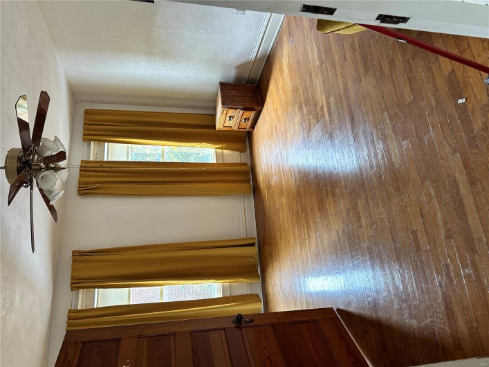 Empty room featuring a textured ceiling, wood finished floors, and ceiling fan