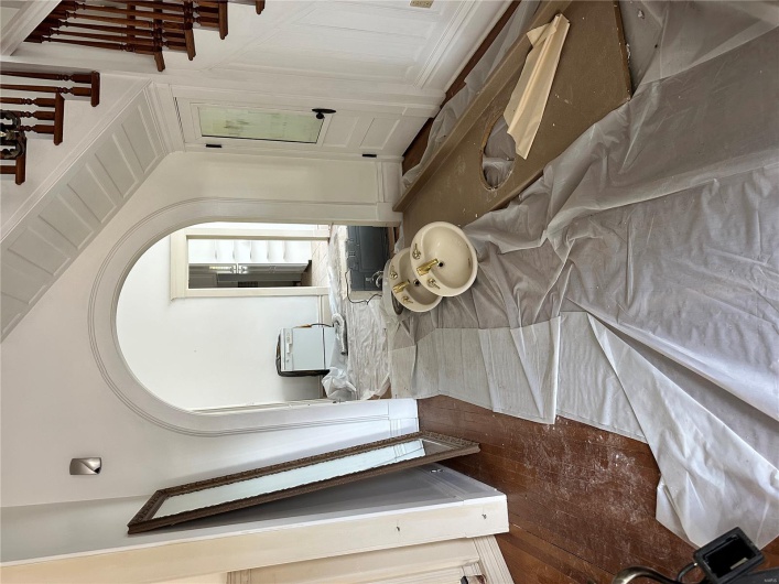 Foyer with arched walkways, vaulted ceiling, and wood finished floors