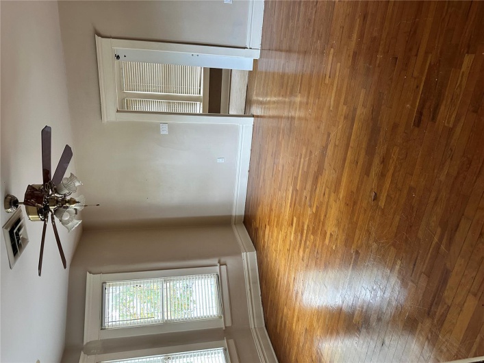 Unfurnished room with baseboards, visible vents, wood finished floors, and a ceiling fan