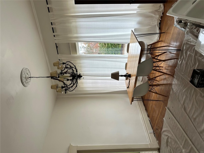 Dining room featuring an inviting chandelier, ornamental molding, baseboards, and wood finished floors