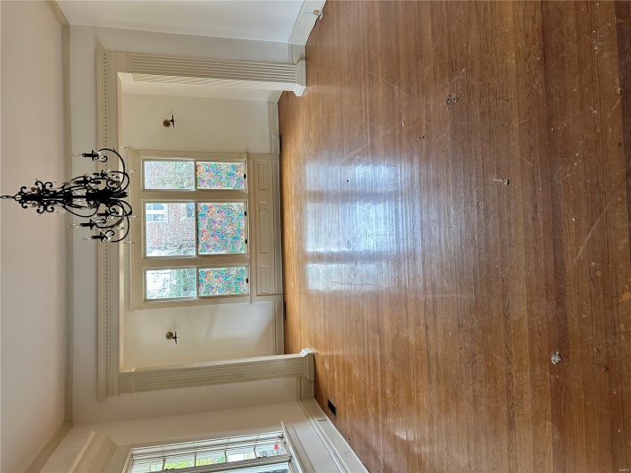 Unfurnished dining area with baseboards, visible vents, an inviting chandelier, and hardwood / wood-style flooring