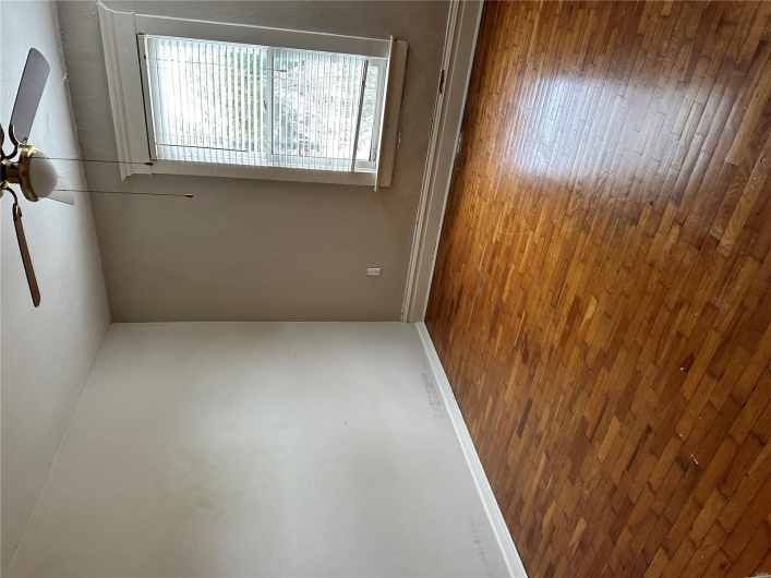 Empty room featuring dark wood finished floors, baseboards, and ceiling fan