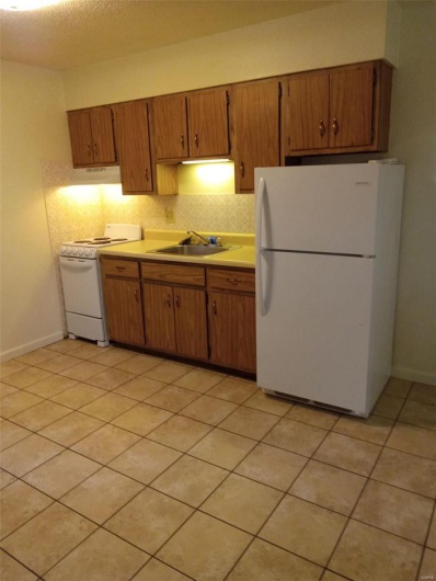 Kitchen featuring sink, tasteful backsplash, a textured ceiling, white appliances, and light tile patterned floors