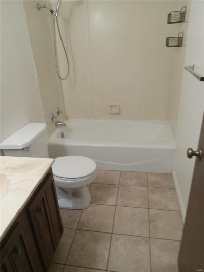 Full bathroom featuring tile patterned floors, vanity, toilet, and tub / shower combination