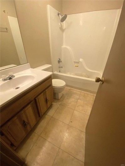Full bathroom featuring tile patterned flooring, vanity, toilet, and shower / bathing tub combination