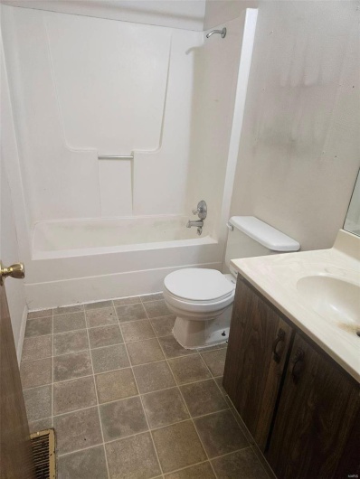 Full bathroom with toilet, vanity, shower / bath combination, and tile patterned floors