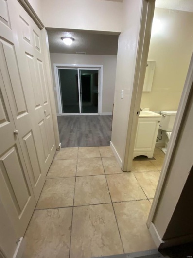 Hallway with light tile patterned flooring