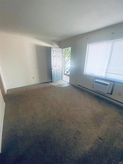Carpeted spare room with a baseboard radiator