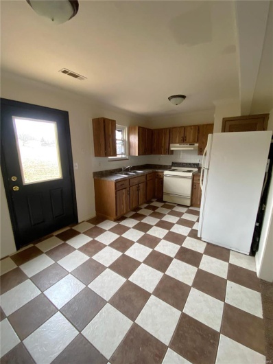 Kitchen featuring a wealth of natural light, sink, and white appliances