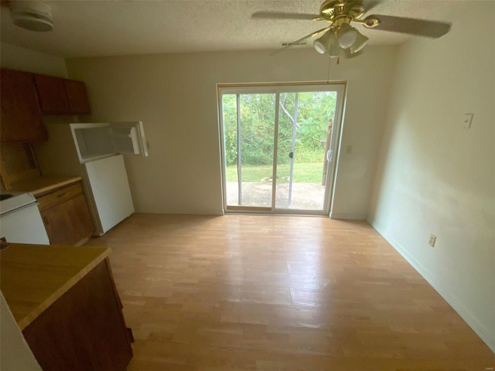 Interior space featuring light wood-type flooring, a textured ceiling, and ceiling fan