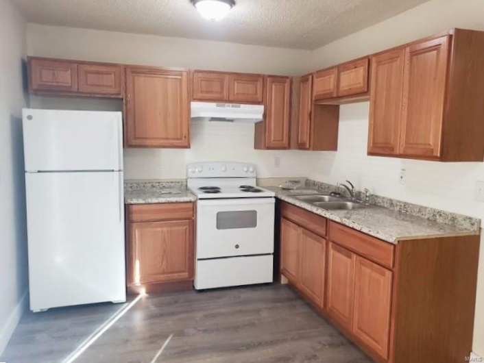 Kitchen featuring a textured ceiling, sink, dark wood-type flooring, and white appliances