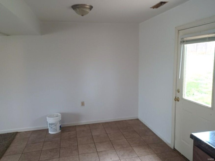 Tiled spare room with a wealth of natural light