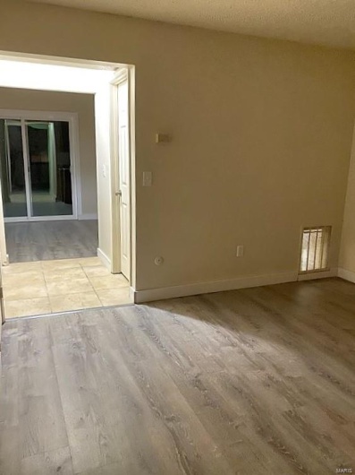 Unfurnished room featuring a textured ceiling and light wood-type flooring
