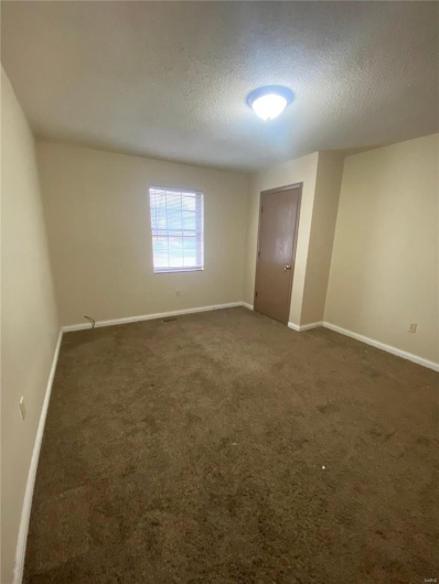 Carpeted spare room with a textured ceiling