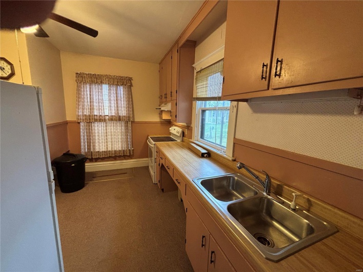 Kitchen featuring ceiling fan, white appliances, plenty of natural light, 