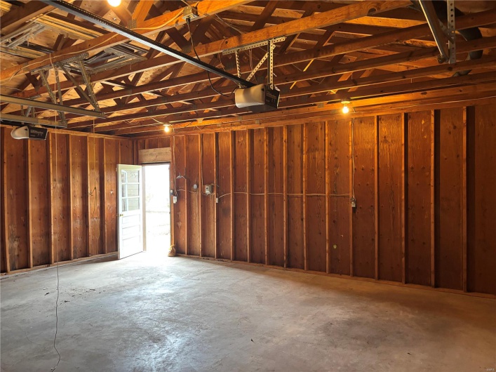 Garage featuring wooden walls and a garage door opener