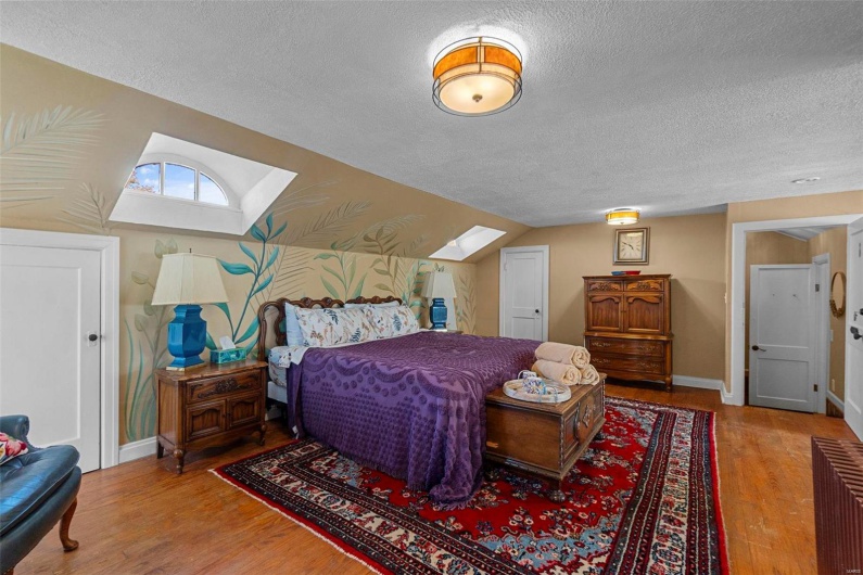 Bedroom featuring wood-type flooring, a textured ceiling, and lofted ceiling