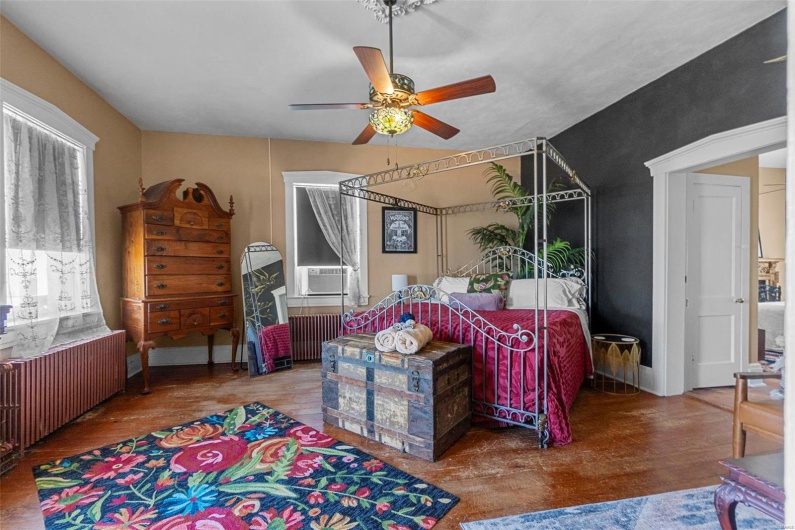 Bedroom featuring radiator heating unit, hardwood / wood-style floors, ceiling fan, and cooling unit