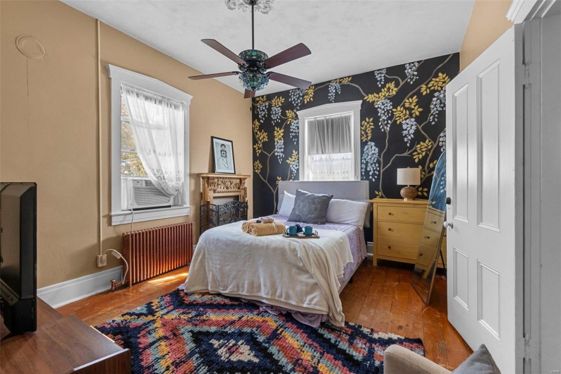 Bedroom with radiator, wood-type flooring, and ceiling fan