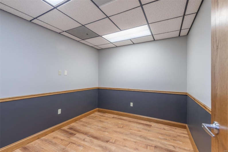 Spare room with a paneled ceiling and wood-type flooring