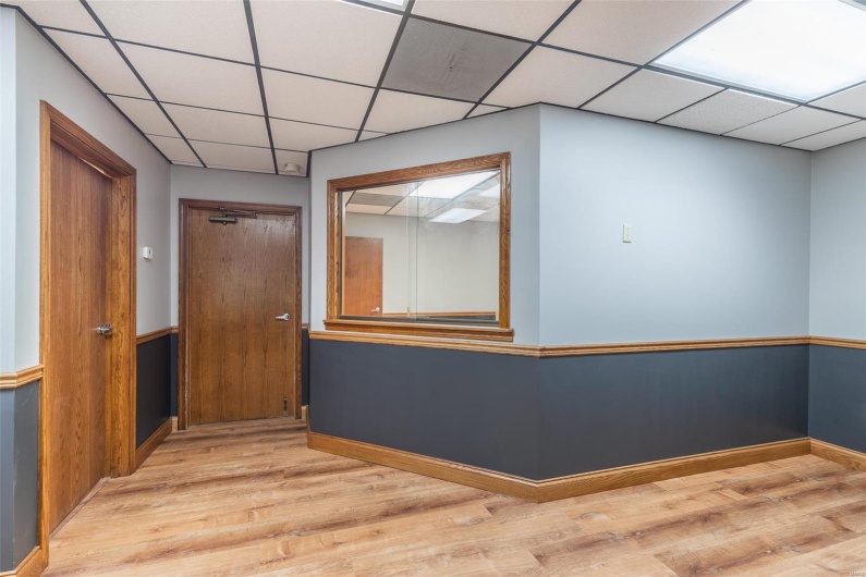 Hall with a paneled ceiling and light hardwood / wood-style flooring