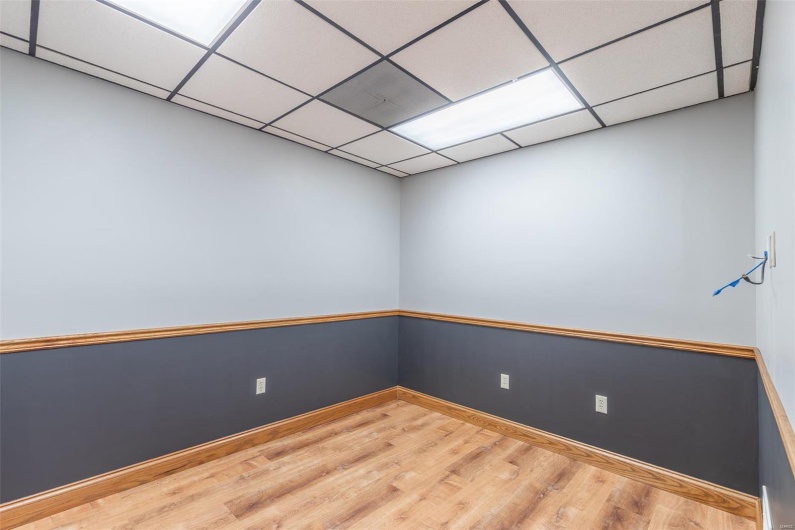 Empty room with a paneled ceiling and hardwood / wood-style flooring