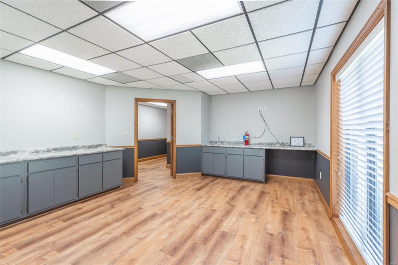 Kitchen with gray cabinetry, a drop ceiling, light hardwood / wood-style floors, and sink