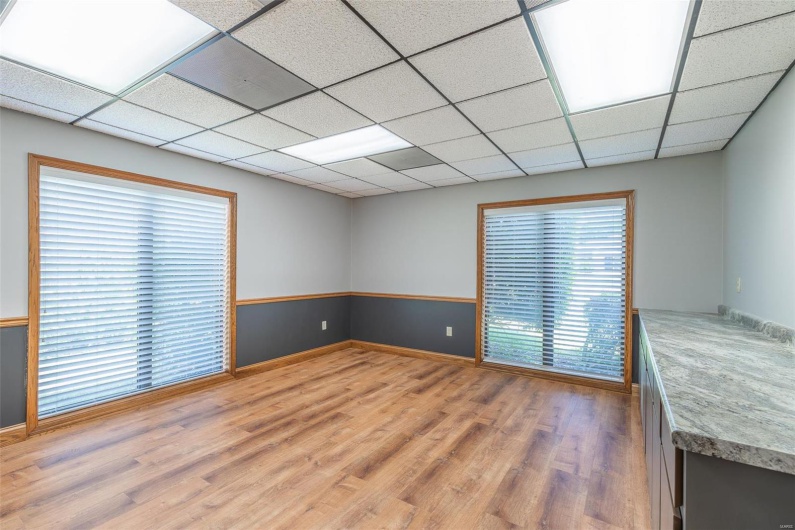 Spare room featuring a paneled ceiling, a wealth of natural light, and wood-type flooring