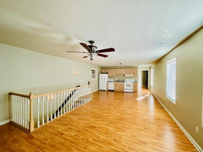 Unfurnished living room featuring ceiling fan and light hardwood / wood-style floors