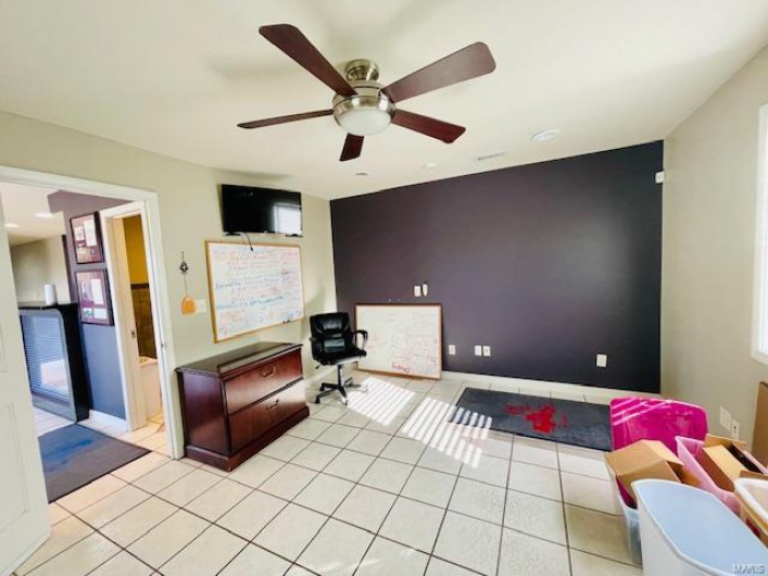 Office area with ceiling fan and light tile patterned flooring