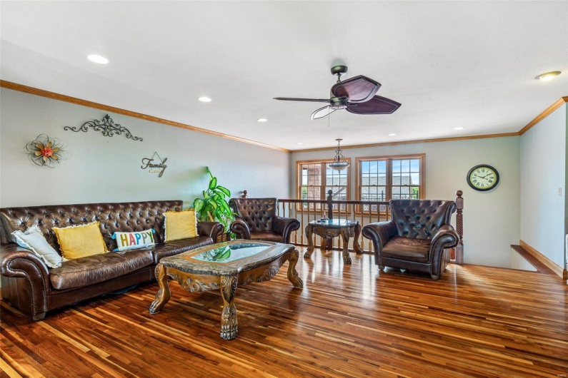 Living room featuring ceiling fan, ornamental molding, and hardwood / wood-style flooring