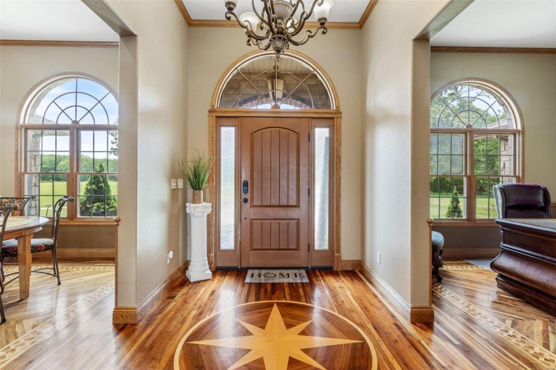 Foyer entrance featuring light hardwood / wood-style floors, crown molding, and a chandelier