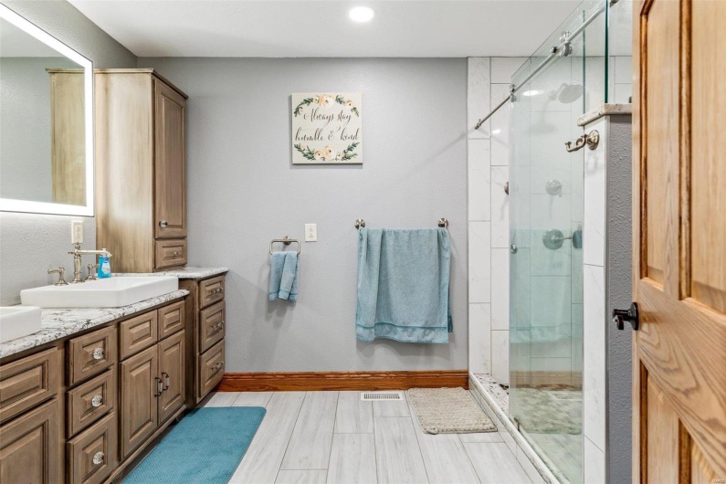 Bathroom with vanity and a shower with door