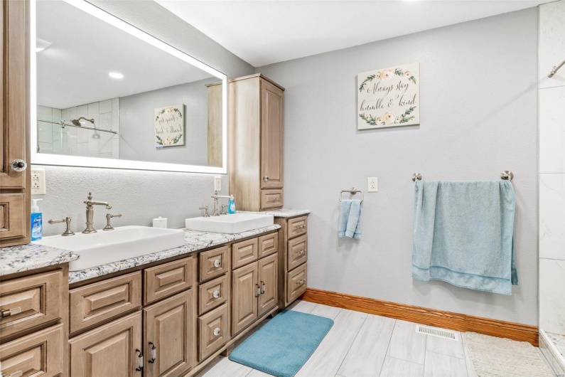 Bathroom featuring tiled shower and vanity