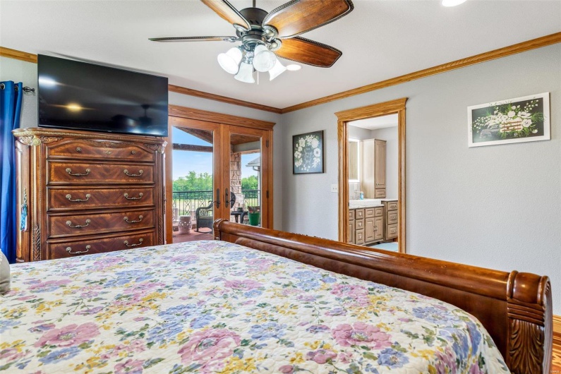 Bedroom featuring french doors, ensuite bath, ornamental molding, access to outside, and ceiling fan