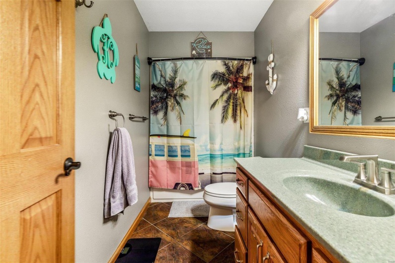 Full bathroom featuring tile patterned floors, vanity, toilet, and shower / tub combo