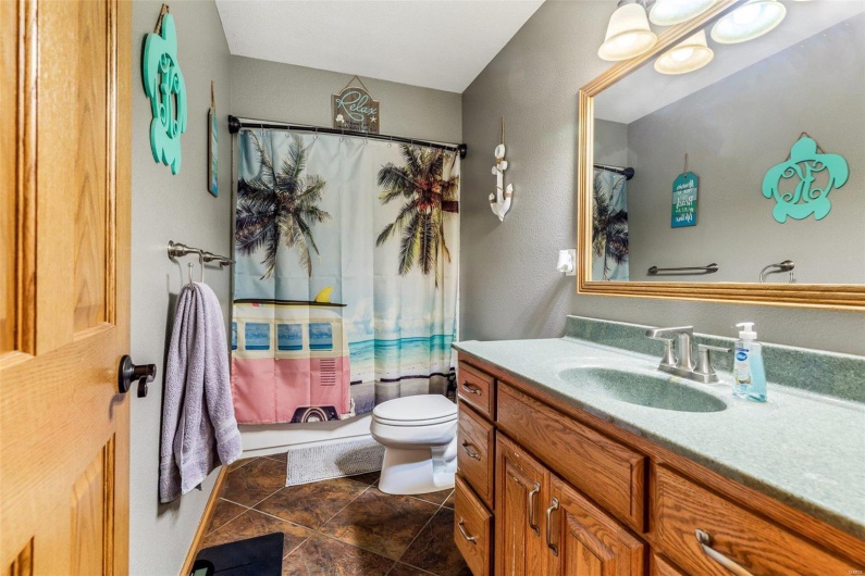 Full bathroom with tile patterned flooring, vanity, toilet, and shower / tub combo