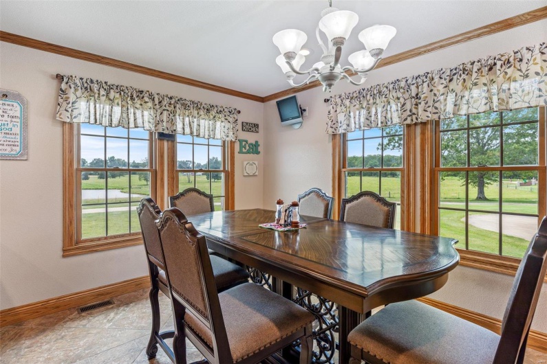 Dining space featuring a chandelier, light tile patterned floors, and crown molding