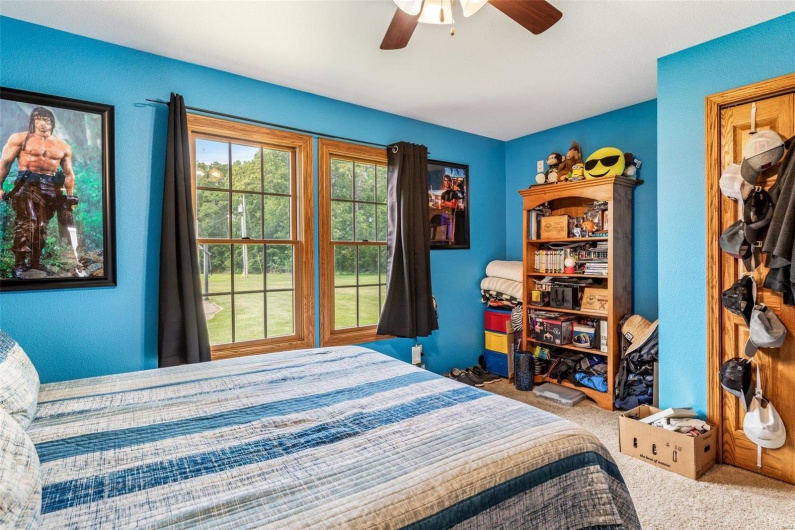 Carpeted bedroom featuring ceiling fan