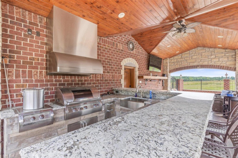View of patio with ceiling fan, a grill, exterior kitchen, and sink