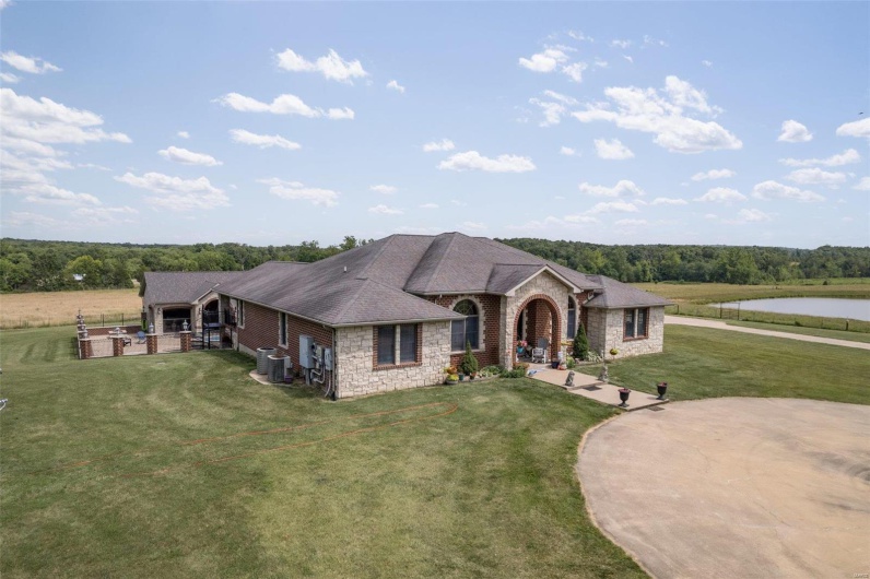 View of front of home featuring a front yard, a water view, and central AC