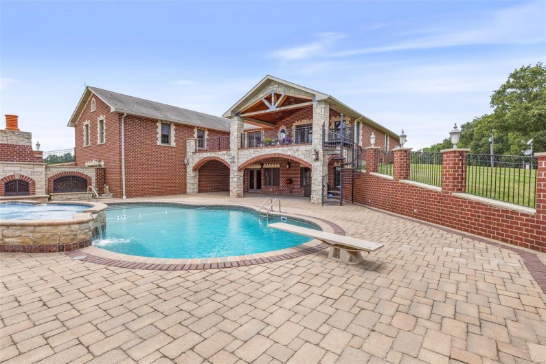 View of pool with an in ground hot tub, pool water feature, and a patio area
