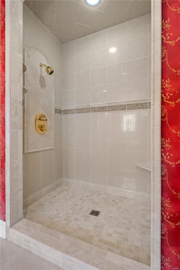 Bathroom featuring tile patterned floors and tiled shower