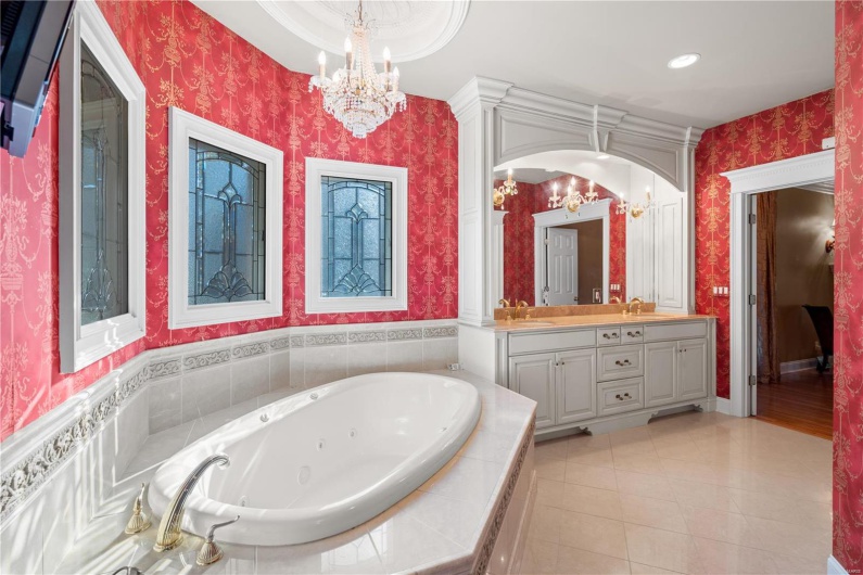 Bathroom with tile patterned floors, tiled bath, and vanity
