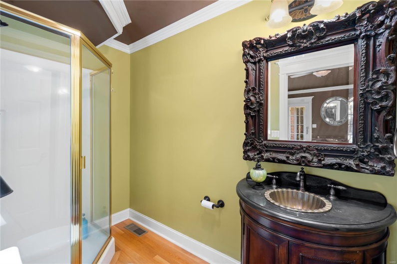 Bathroom with walk in shower, vanity, wood-type flooring, and ornamental molding