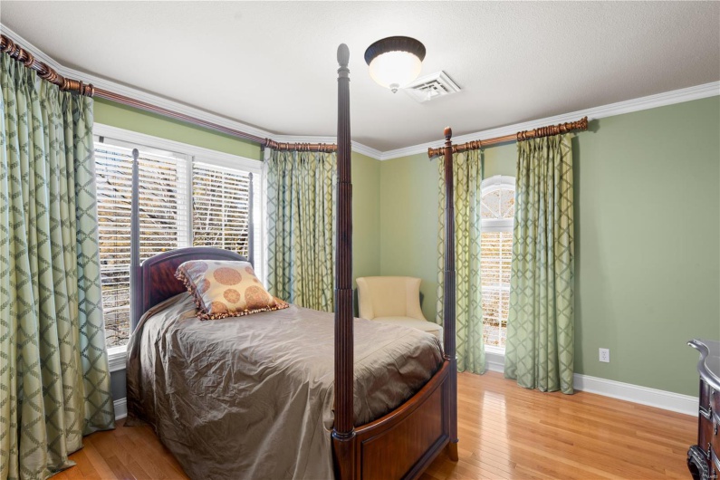 Bedroom featuring hardwood / wood-style flooring and crown molding