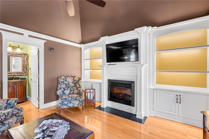Living room with wood-type flooring, ceiling fan, and lofted ceiling