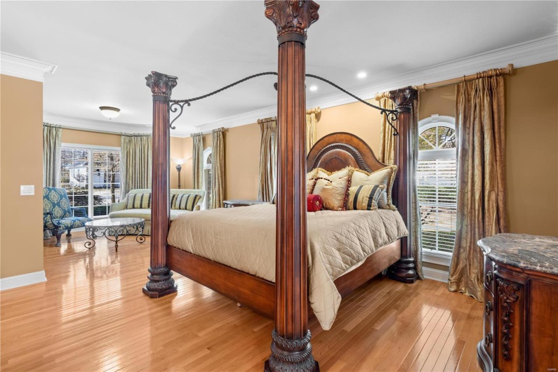 Bedroom with multiple windows, light hardwood / wood-style flooring, and ornamental molding
