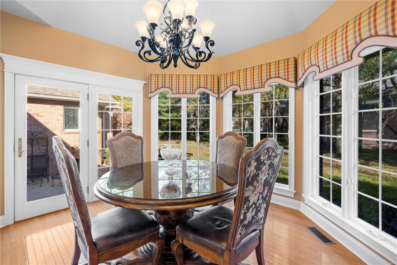 Dining space with light hardwood / wood-style floors, a wealth of natural light, and an inviting chandelier