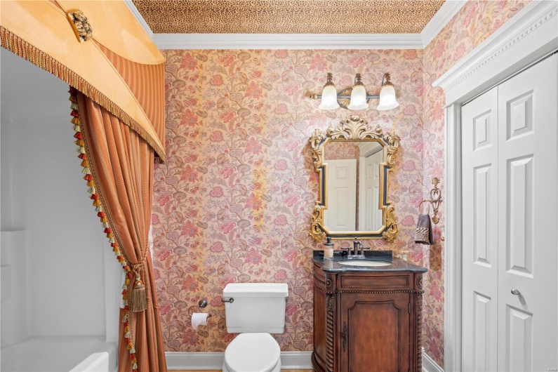 Bathroom featuring vanity, toilet, and crown molding